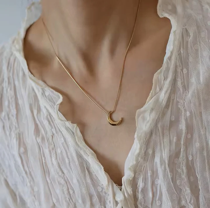 woman wearing gold plated necklace